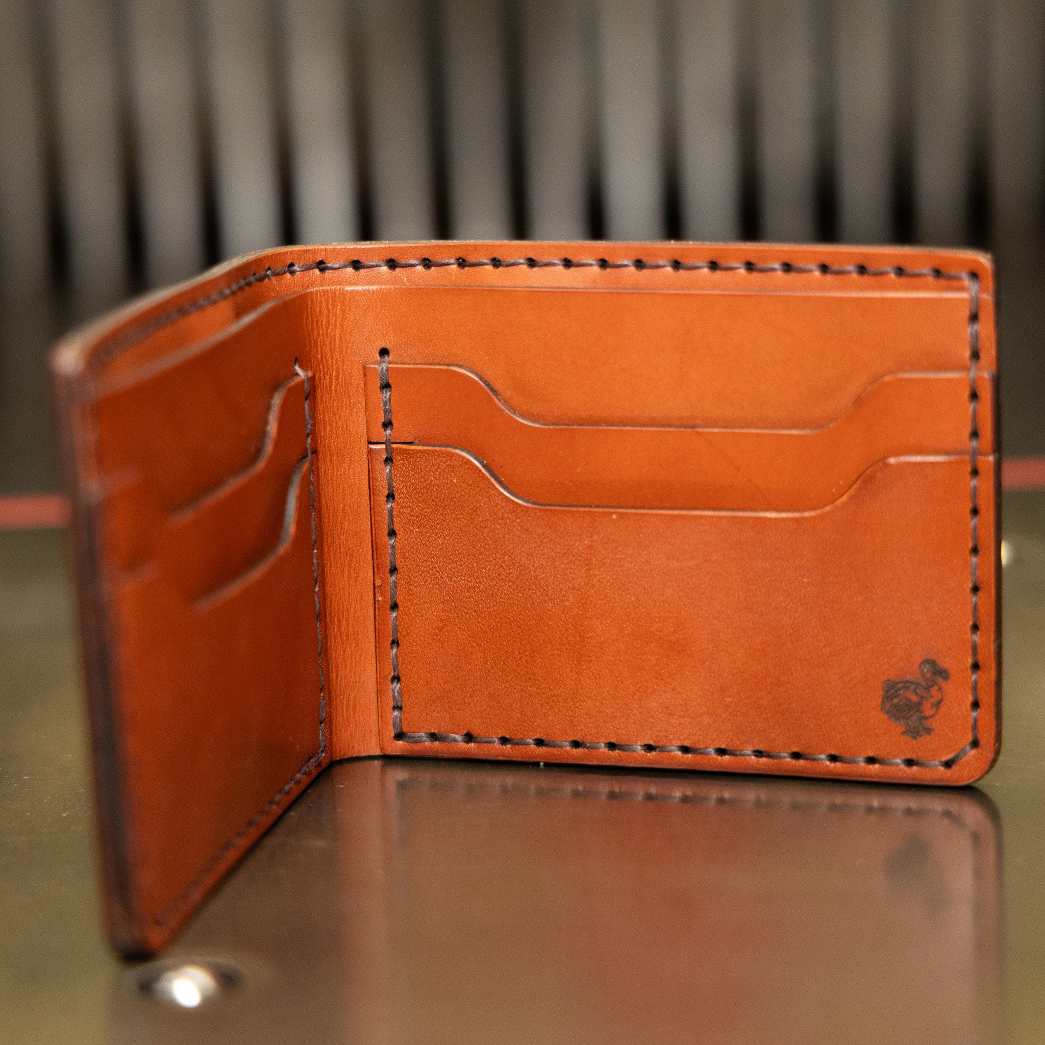 Leather bifold wallet in chestnut English Bridle standing open, four card pockets, handmade in USA