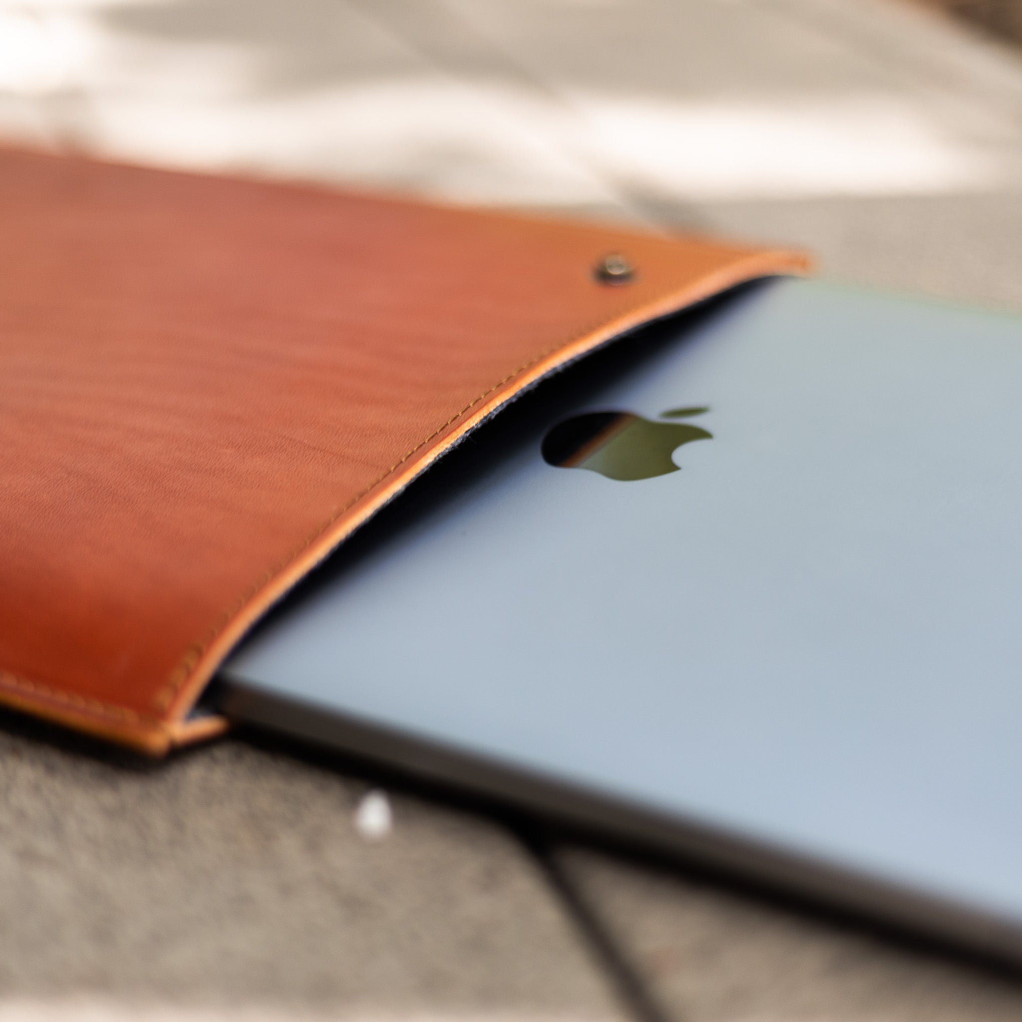 Leather MacBook sleeve open with a MacBook Pro partly inserted