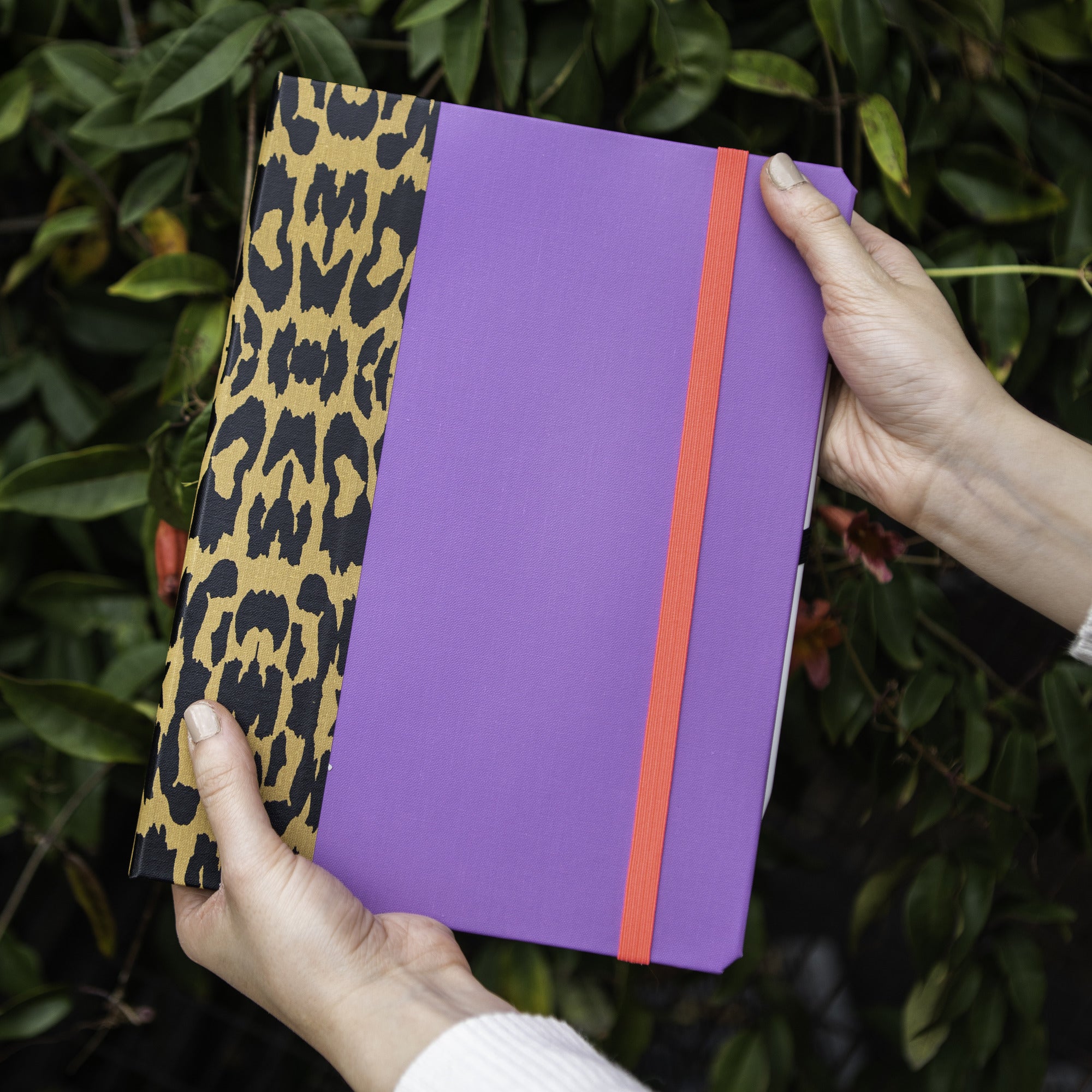 Custom book-style iPad case in purple with leopard-print spine, handmade in the USA by DODOcase
