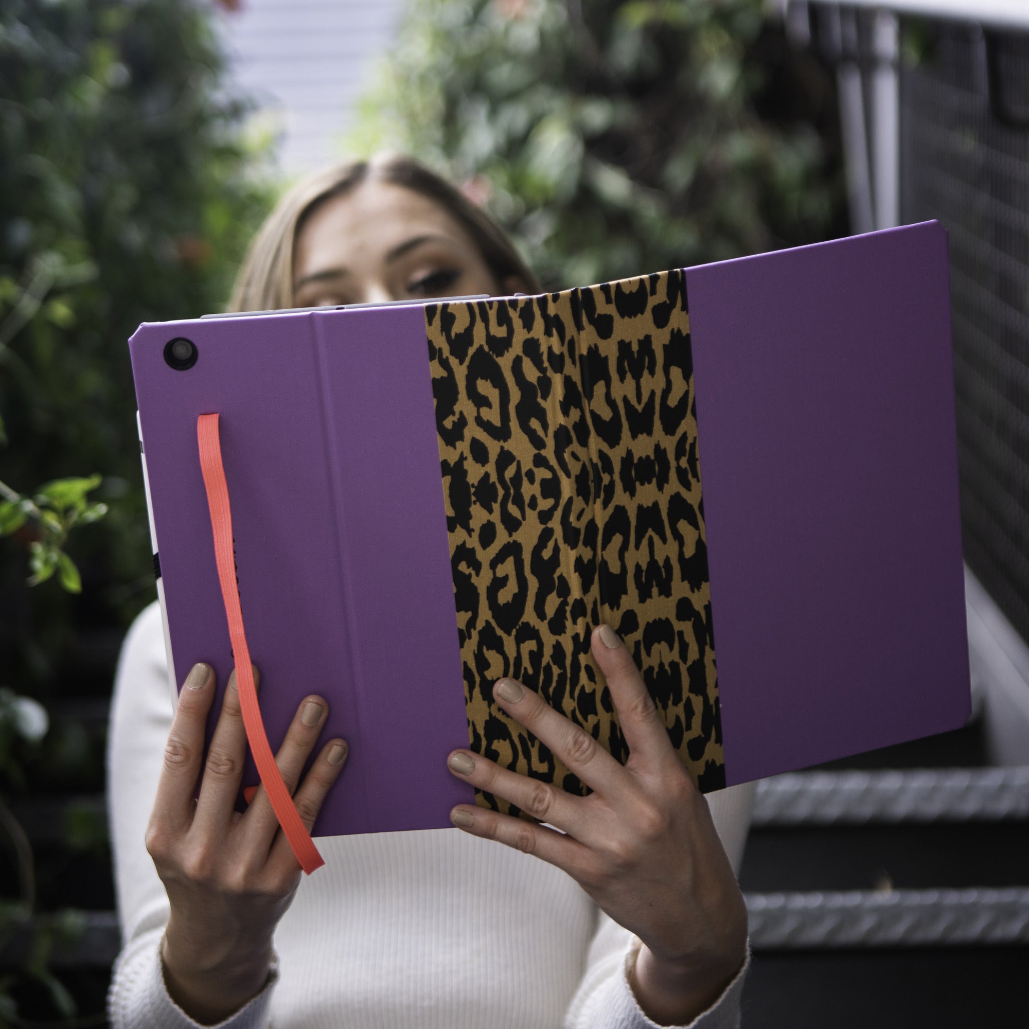 Custom book-style iPad case held open, showing the leopard-print interior panel