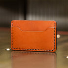 Two pocket slim leather card holder showing scooped card pocket and saddle stitching
