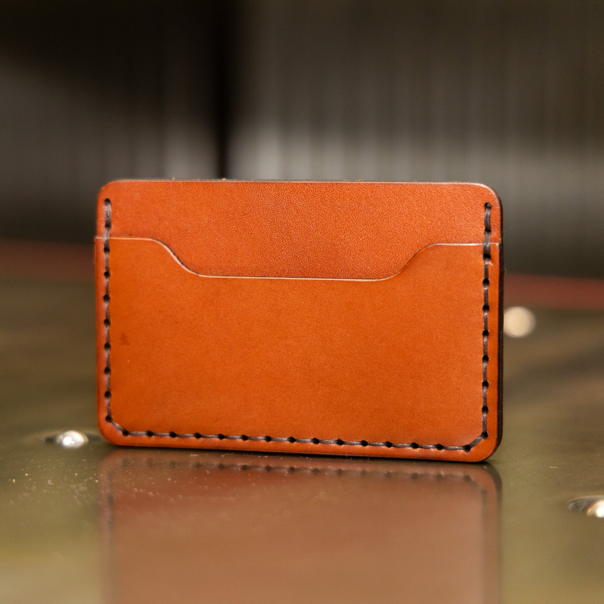 Two pocket slim leather card holder showing scooped card pocket and saddle stitching