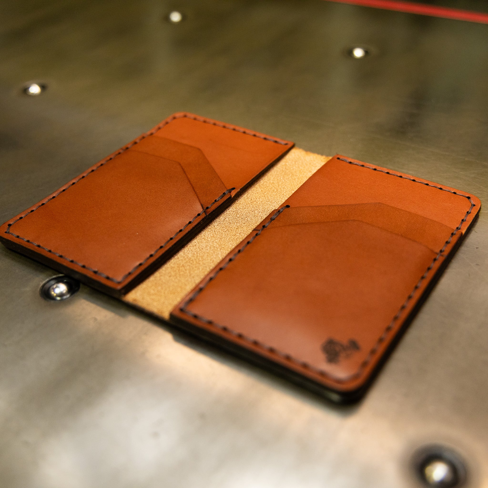 Slim bifold wallet in vertical format, chestnut full grain leather with dodo stamp