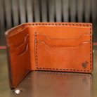 Leather bifold wallet in chestnut English Bridle standing open, four card pockets, handmade in USA