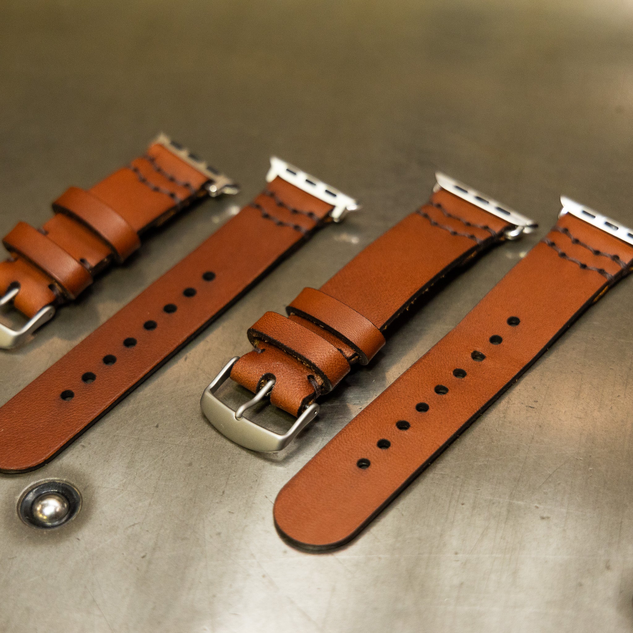 Handsewn leather Apple Watch bands in both sizes showing buckles and stitching