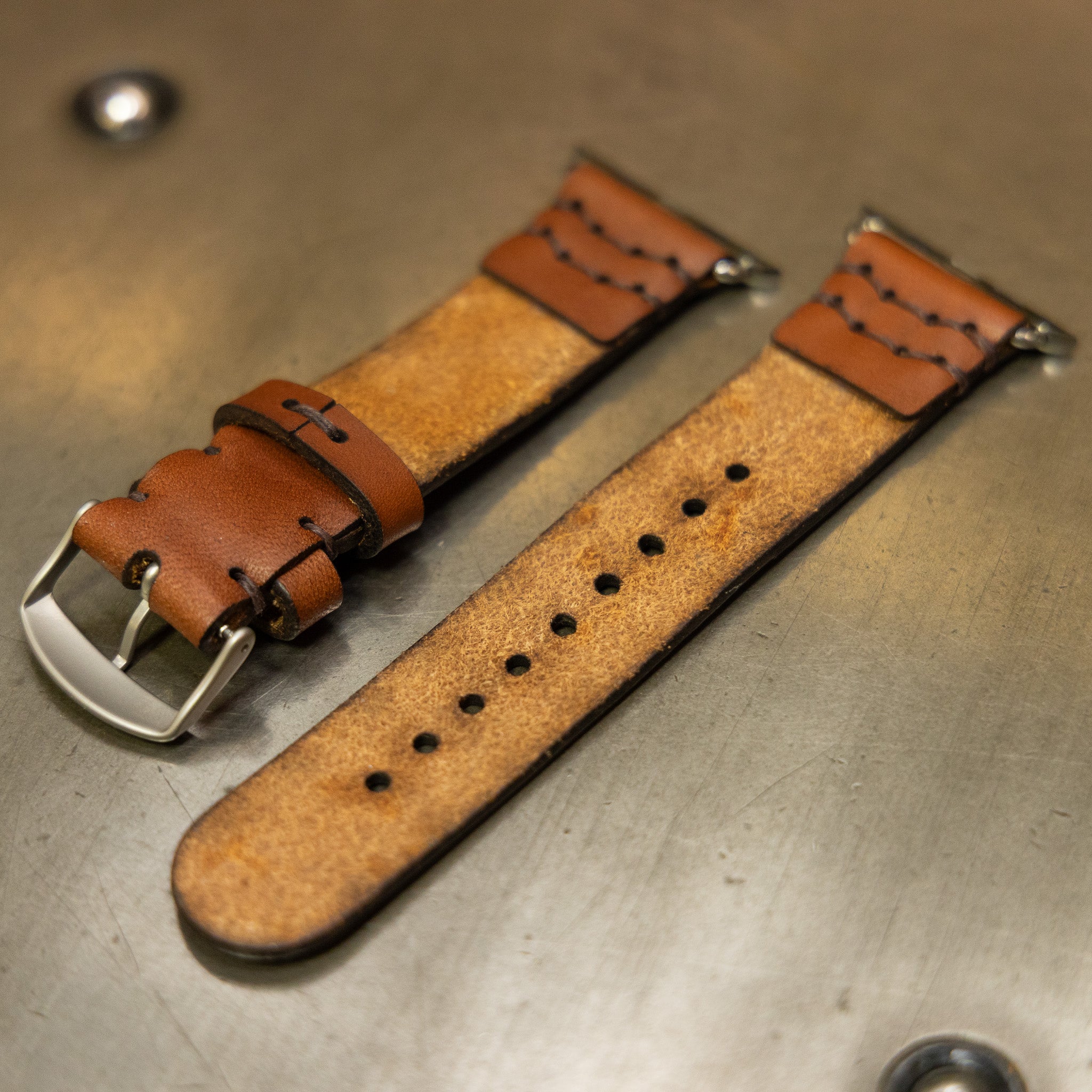 Leather Apple Watch band showing suede underside and hand-punched holes