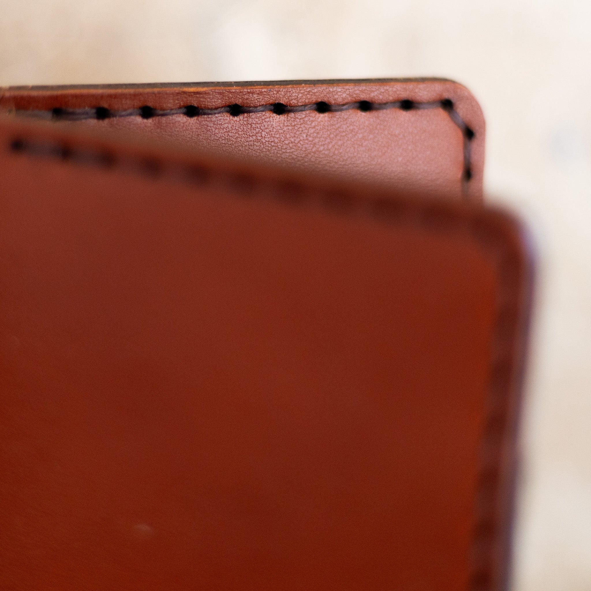 Macro close-up of English Bridle leather and hand stitching on bifold wallet