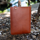 Chestnut English Bridle leather MacBook sleeve, front view with brass snap tab