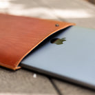 Leather MacBook sleeve open with a MacBook Pro partly inserted