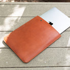 MacBook sliding out of a Chestnut leather sleeve