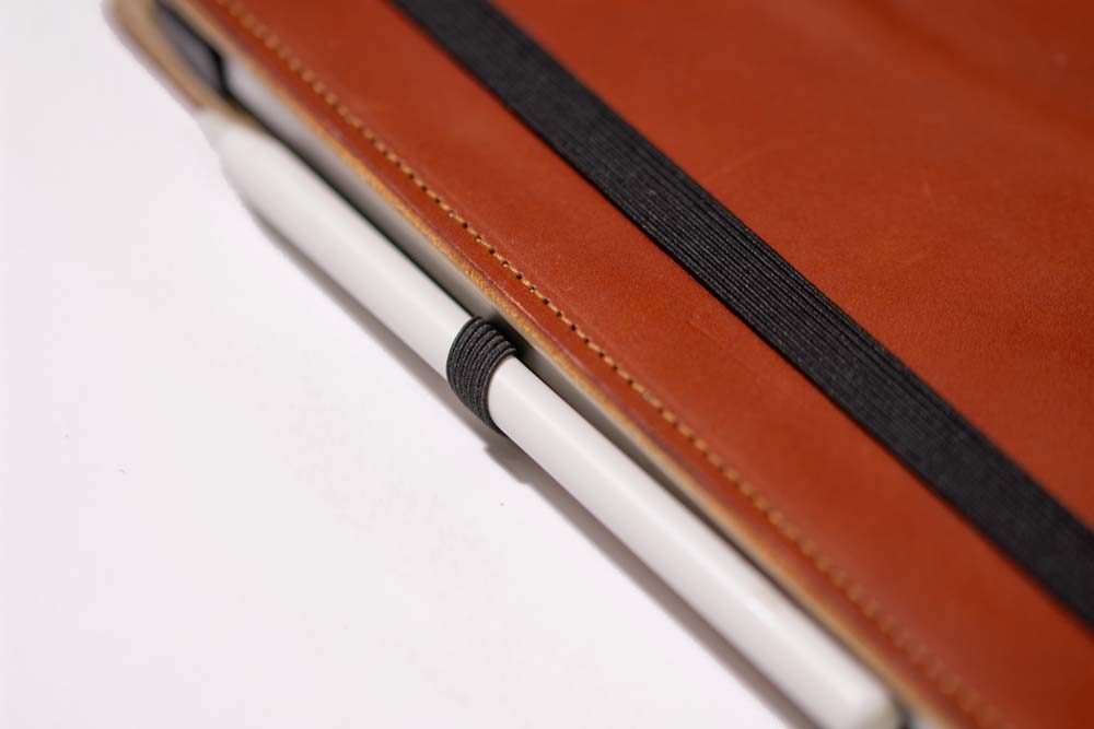 Apple Pencil Pro held with elastic on leather iPad case