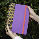 Custom book-style iPad case in purple with leopard-print spine, handmade in the USA by DODOcase