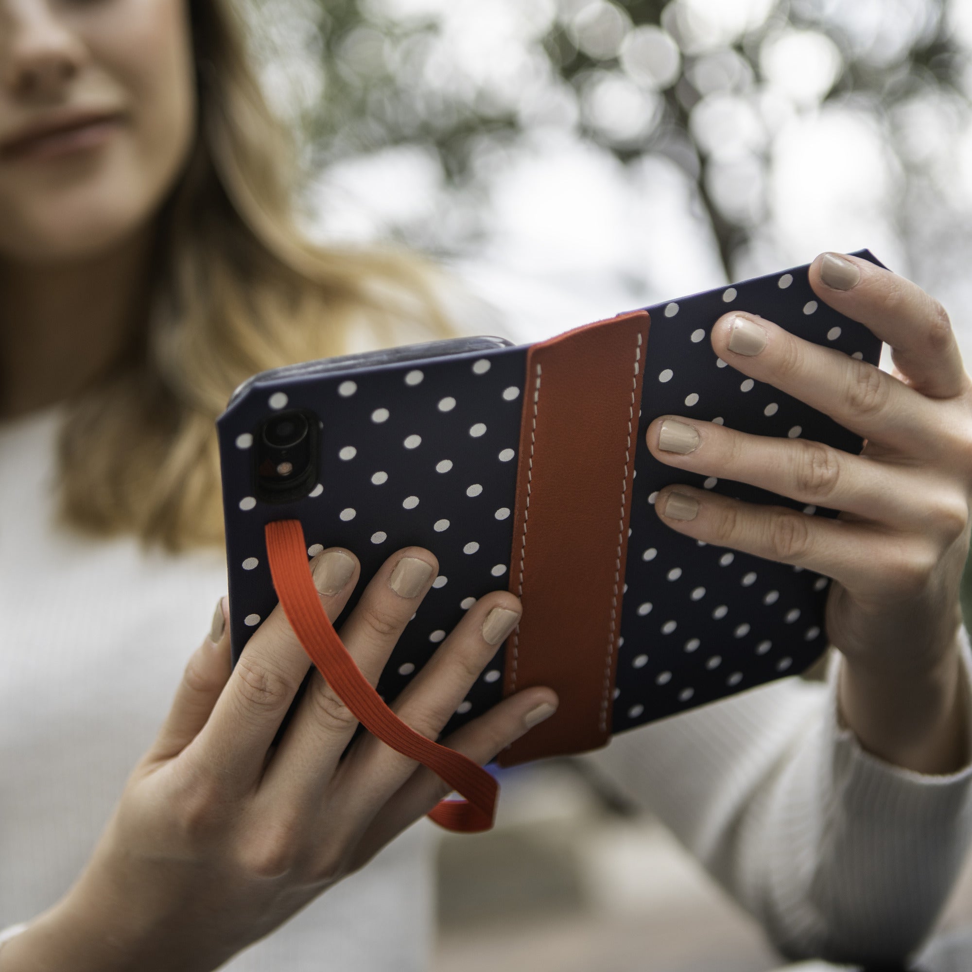 Custom iPhone wallet case in navy polka dot with leather strap, handmade in the USA by DODOcase