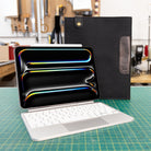 Black iPad keyboard sleeve on a green cutting mat in a workshop setting
